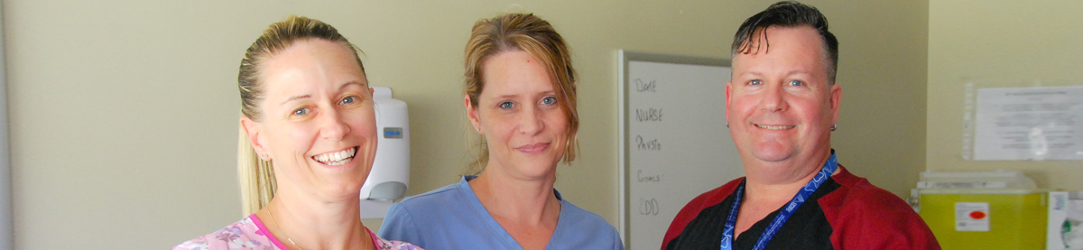 3 healthcare workers smiling at camera