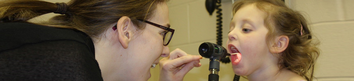 Doctor examining young girl's throat