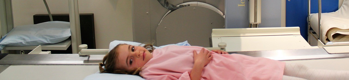 Young girl lying down on a diagstostic imaging table