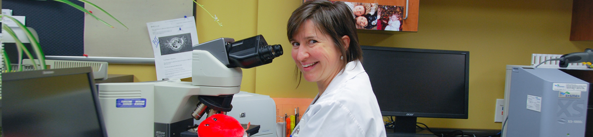 Healthcare worker sitting in front of microscope
