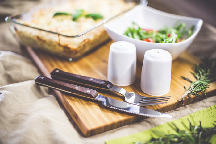 Cutting board, salad in a bowl with cutlery